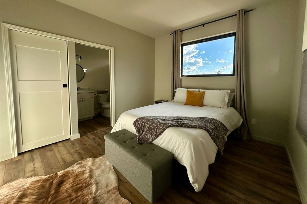 Sleep well one of the two spacious bedrooms.  Each had a walk-in closet, queen bed, luxury linens, full length mirror, own mini-split and bathroom.   The gorgeous picture windows have blackout curtains for night.  This room has a storage bench.  