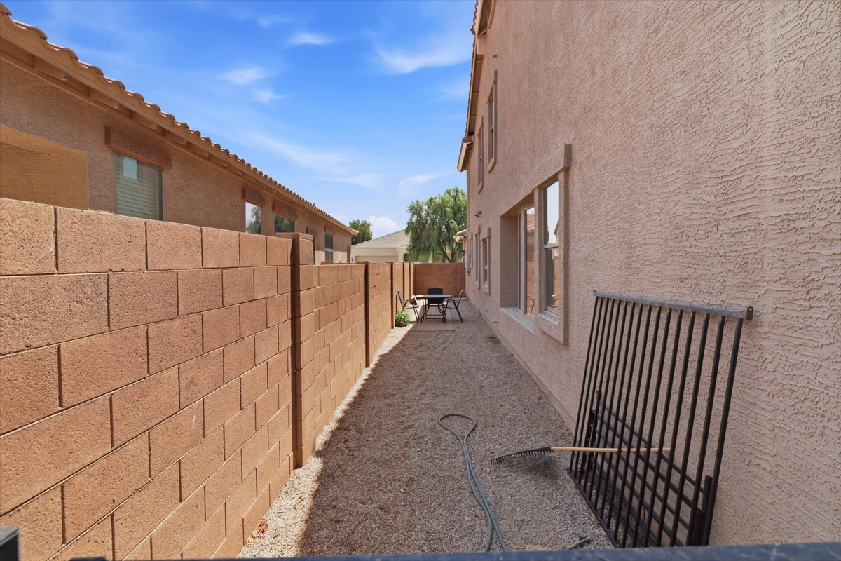 Side yard with gravel space and access along the side of the home.