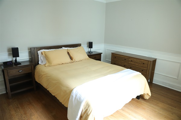 SE Bedroom showing queen size bed, nightstands with touch lamps and alarm clock, and dresser