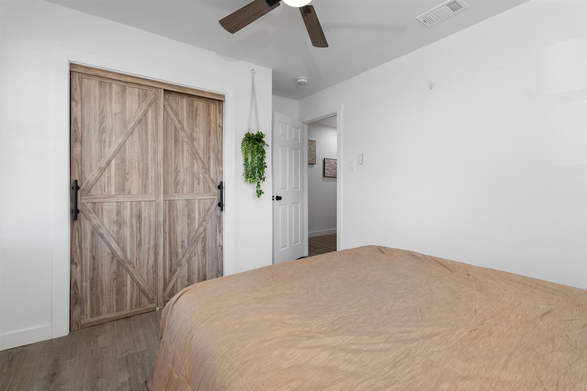 Comfortable queen bedroom with soft bedding, ceiling fan, and ample closet space. Includes fresh linens, extra blankets, and hangers for easy organization.