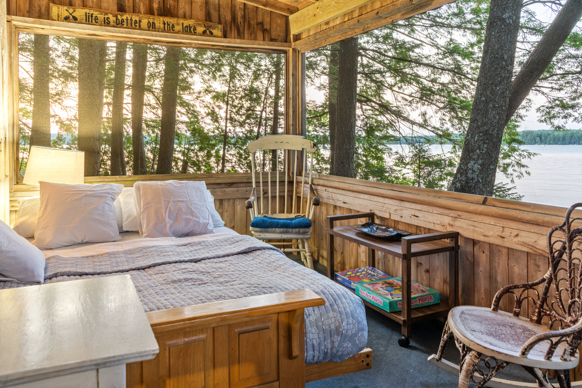 Wrap-around water views from the screened porch bed at Loonrise Point! Wake up surrounded by pine trees, soft breezes, and lake vistas on Beech Hill Pond in Otis, ME. Features cozy seating, board games, and ultimate rustic charm!