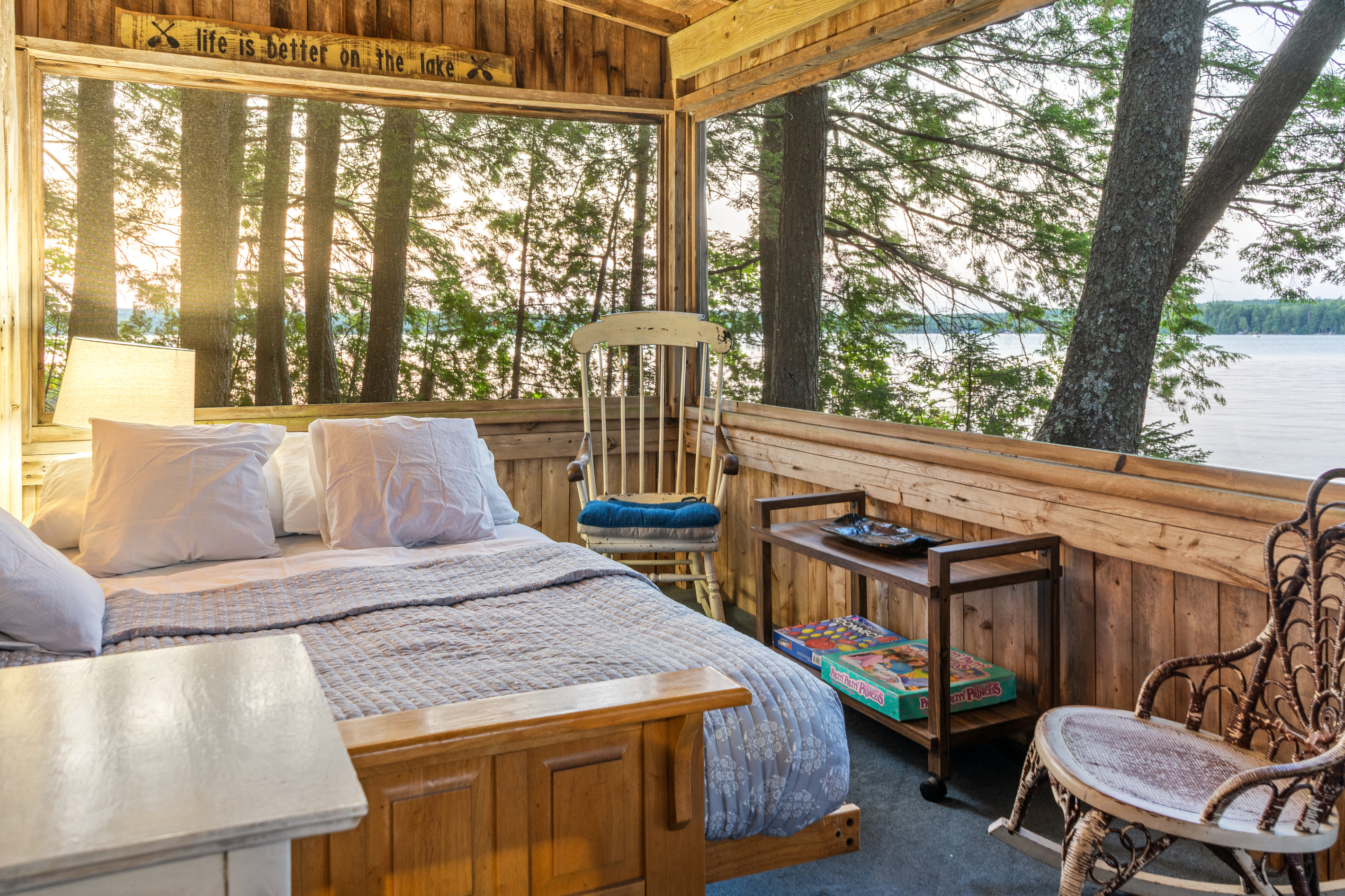 Wrap-around water views from the screened porch bed at Loonrise Point! Wake up surrounded by pine trees, soft breezes, and lake vistas on Beech Hill Pond in Otis, ME. Features cozy seating, board games, and ultimate rustic charm!