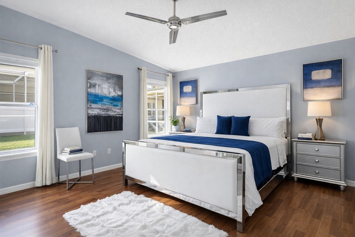 Spacious KING Master Bedroom with modern decor and natural light from two windows.