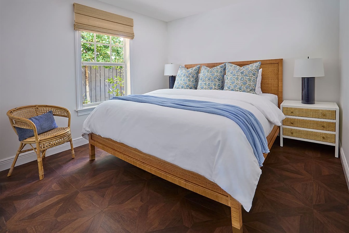 The second bedroom features a Serena & Lily rattan bed dressed in luxurious 800-thread-count linens, an award-winning WinkBed mattress, a TV, and ample storage for your belongings.