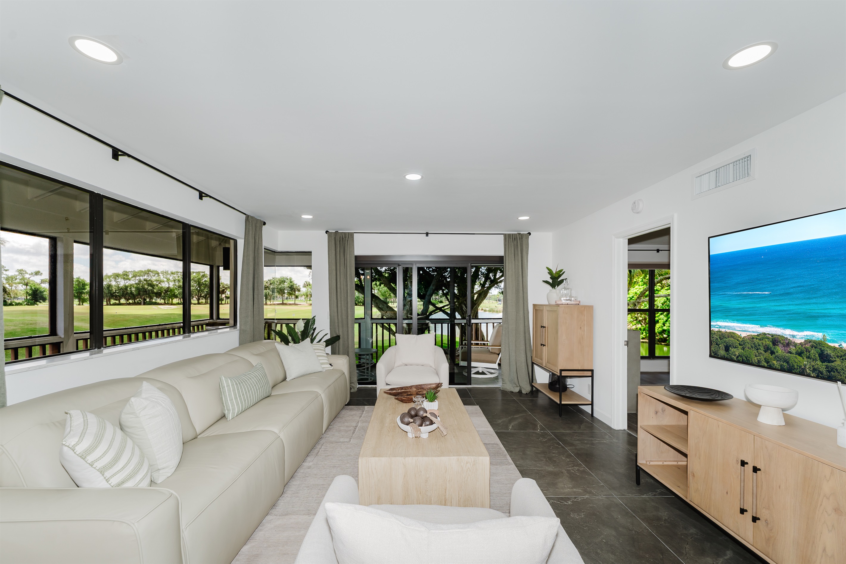 Bright, open living space filled with natural light and golf course views. Comfortable seating is perfect for relaxing after a day at the beach or golf. A spacious living area designed for both comfort and style.