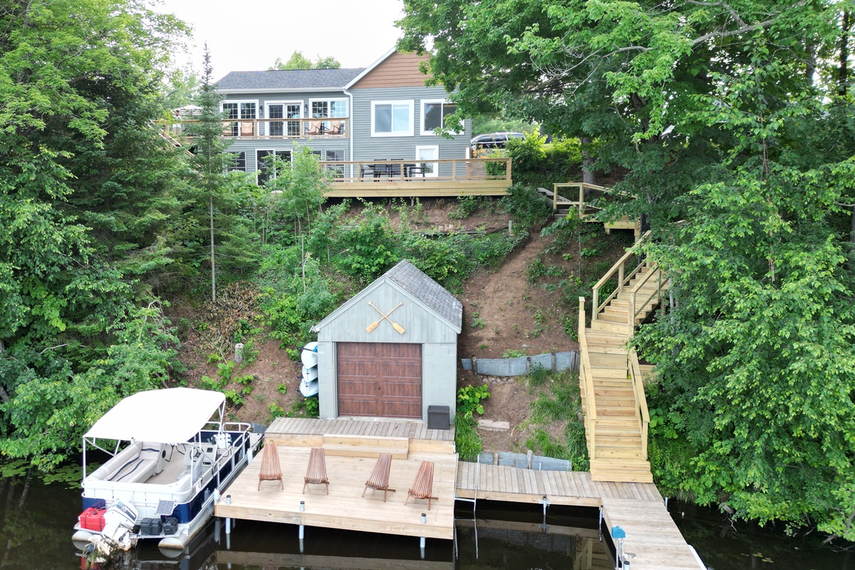 A serene dock with cozy chairs, right by the lake! Enjoy peaceful moments or launch a kayak from the shed for a fun adventure. 
