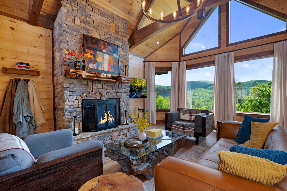 Your luxe mountain getaway awaits! Cozy living room with wood burning fireplace and jaw dropping views!
