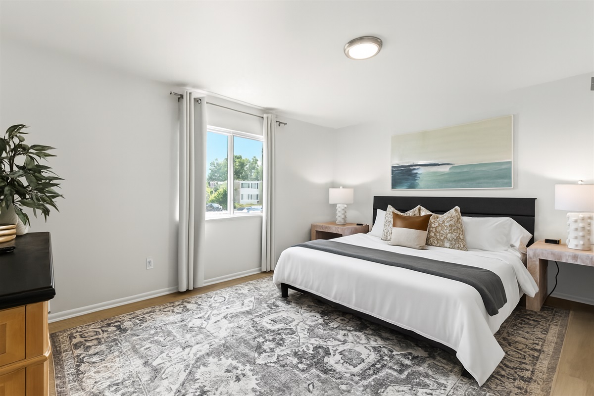 Natural light floods this spacious bedroom, offering serene views and a calm atmosphere to unwind.