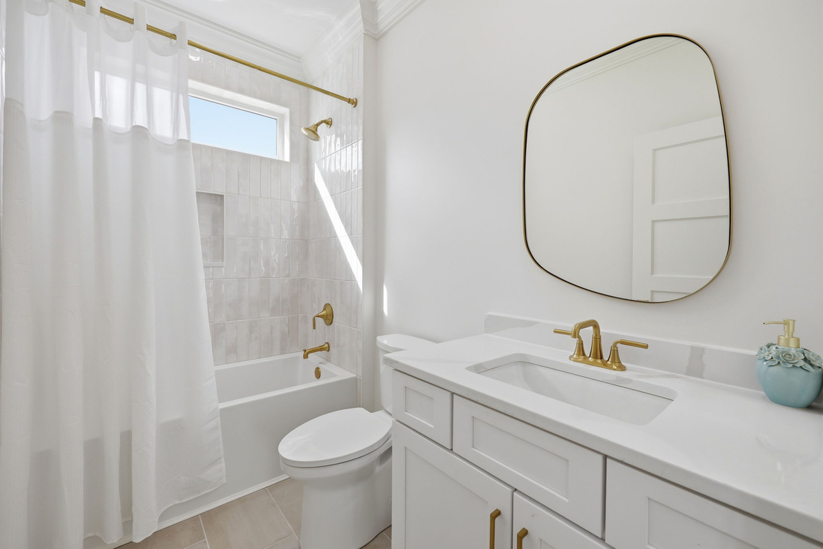 1st floor bathroom with tub/shower combo, gold fixtures, and clean modern vanity