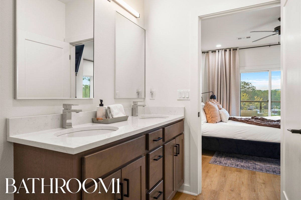 Bathroom 1: Elegant double-vanity space with premium finishes and bright natural lighting.