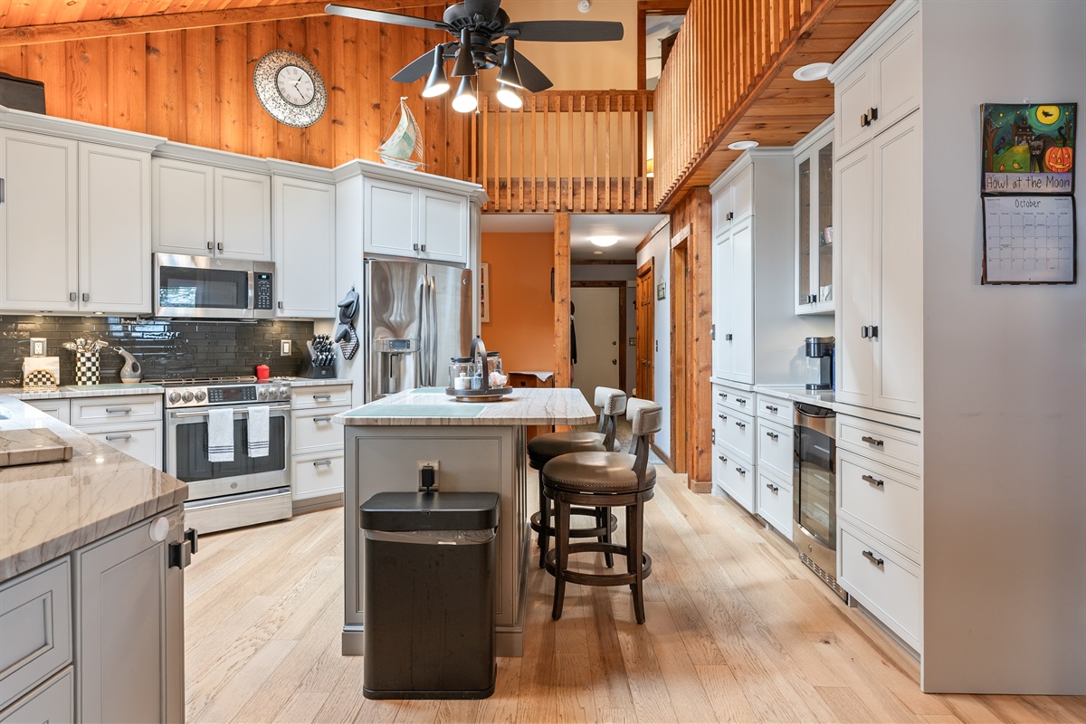 Modern kitchen with stainless steel appliances, island seating, and wood accents — perfect for cooking and entertaining