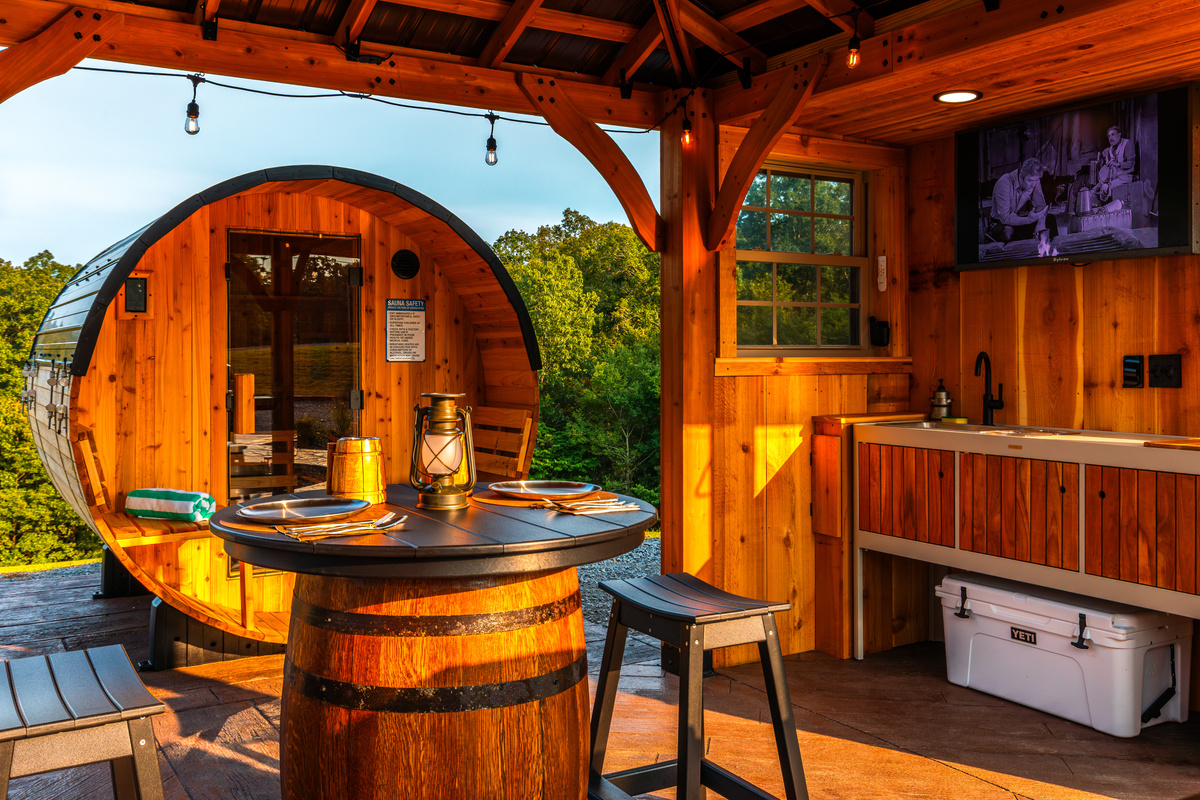 Covered outdoor dining beside the sauna, outdoor kitchen, and TV pavilion.
