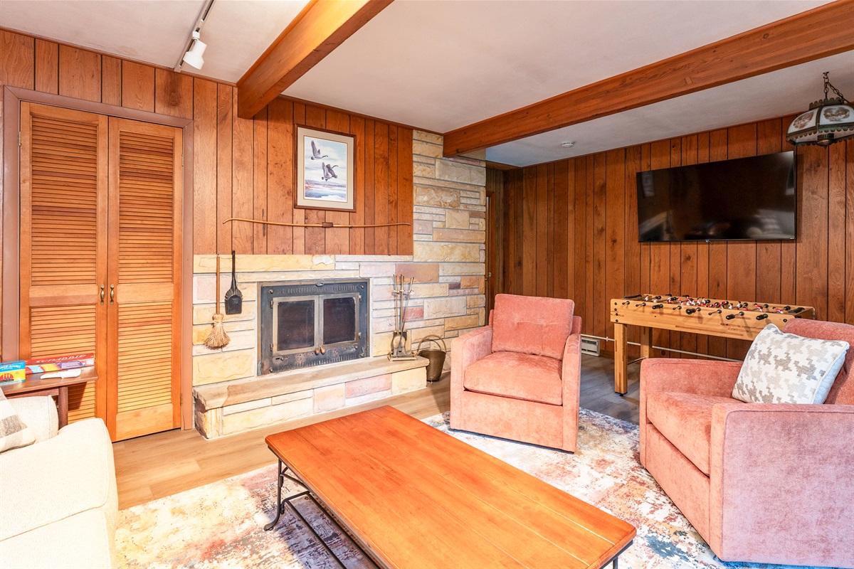 Fun-filled family room featuring foosball, plush seating, and sliding doors that open to the outdoors—ideal for game nights and relaxation.