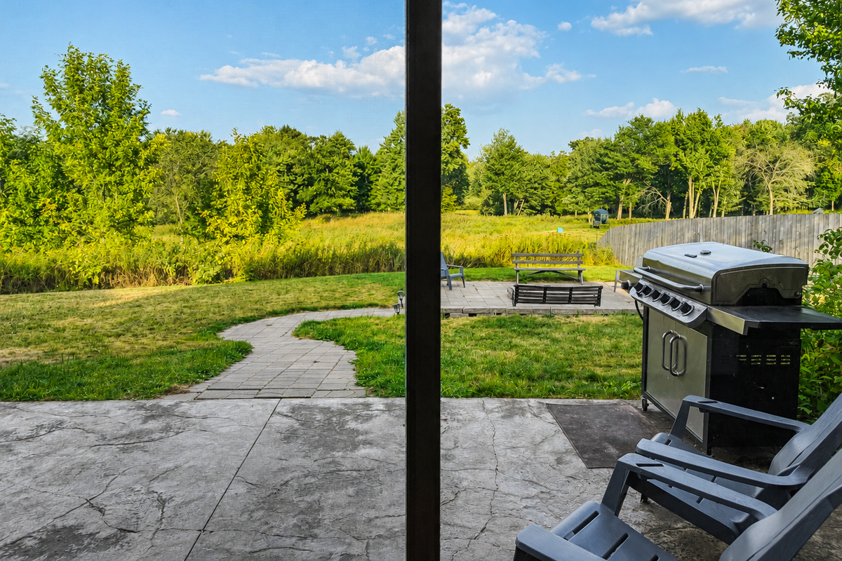 Step outside to the patio and grill area with peaceful views of the surrounding Northwoods property, perfect for cooking outdoors, relaxing in the fresh air, and enjoying your Wisconsin getaway.