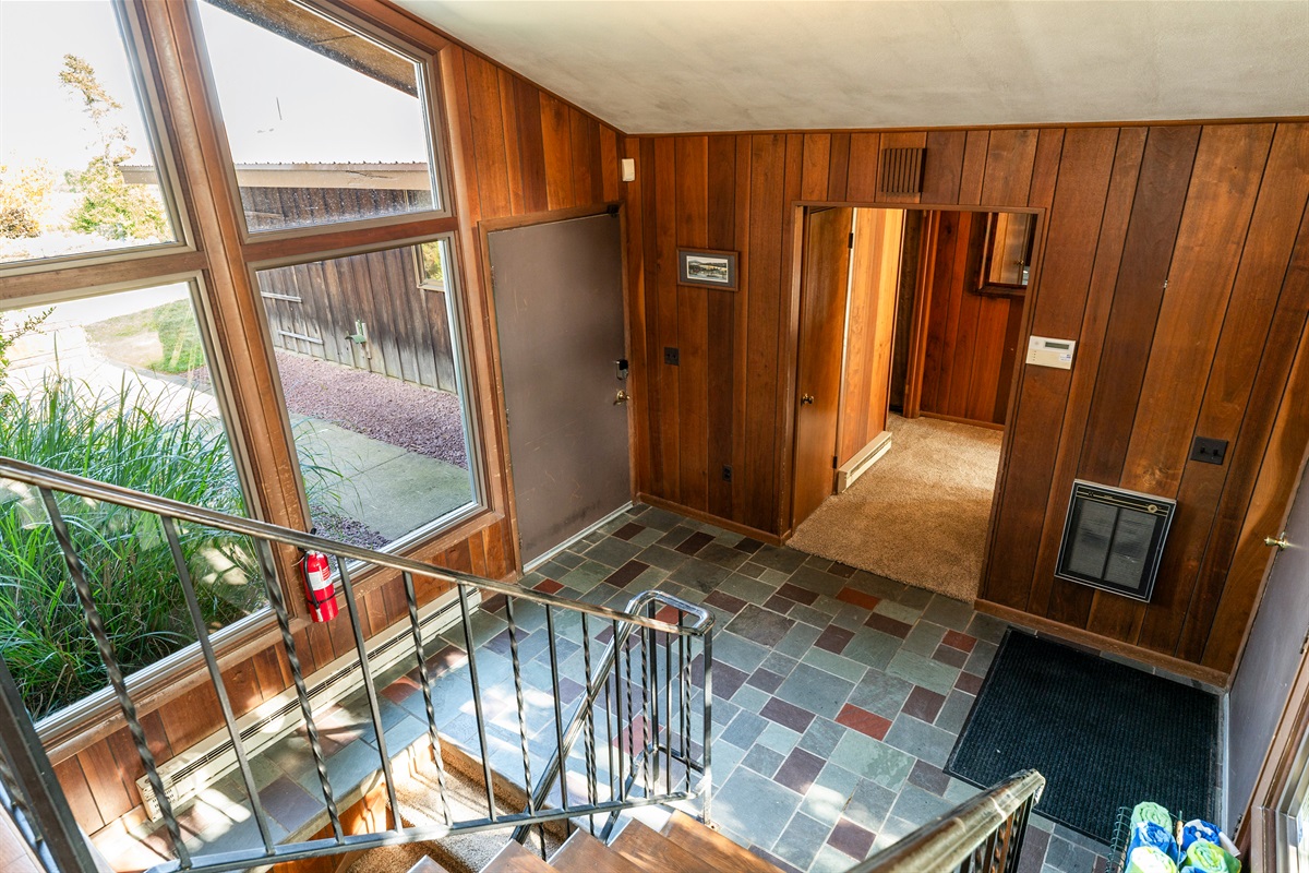 Open foyer with expansive windows, slate tile floors, and a rustic-modern design full of natural light.