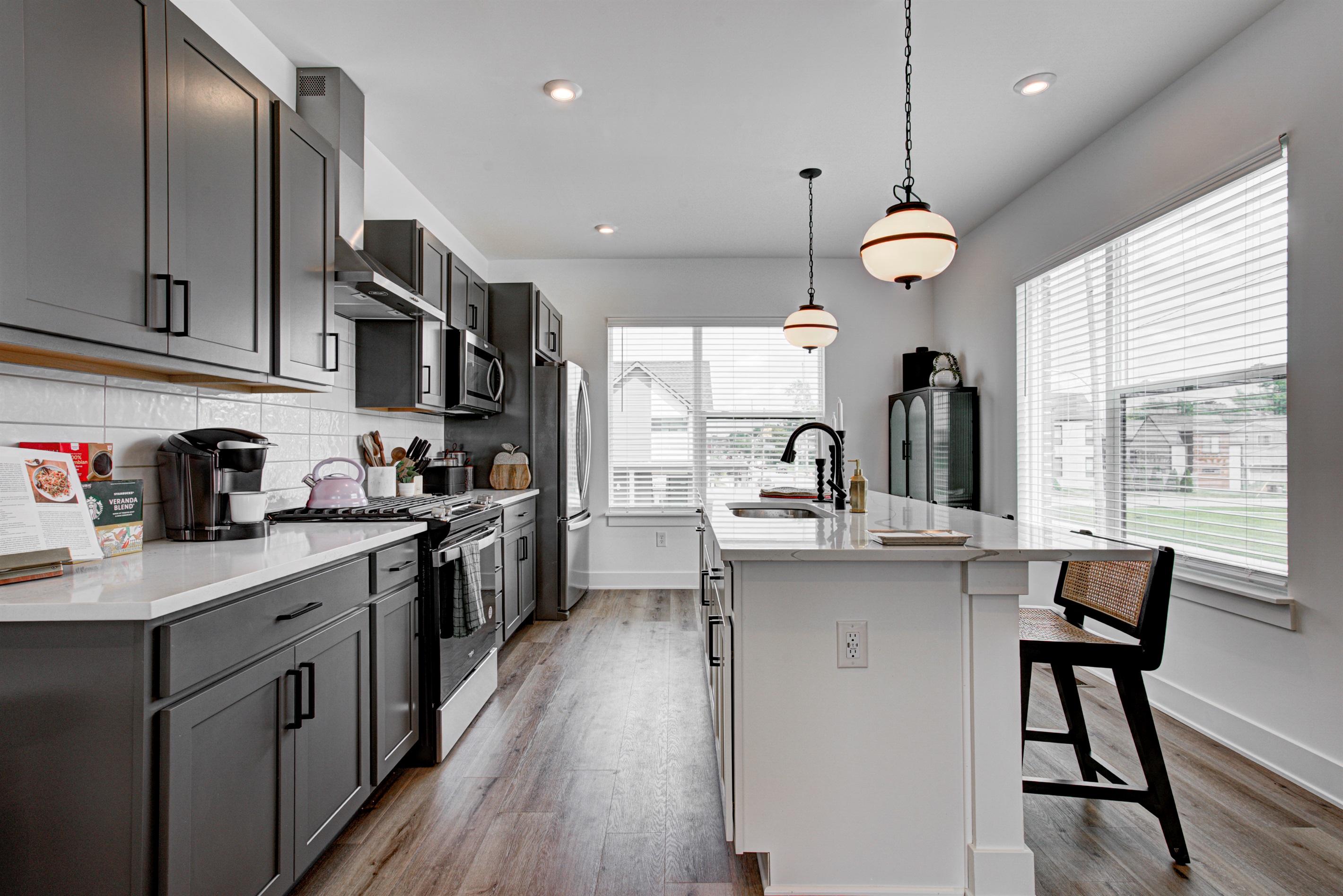 Enjoy a designed open-concept space with a modern kitchen equipped with quartz countertops, stainless steel appliances, and all essentials for home cooking. 