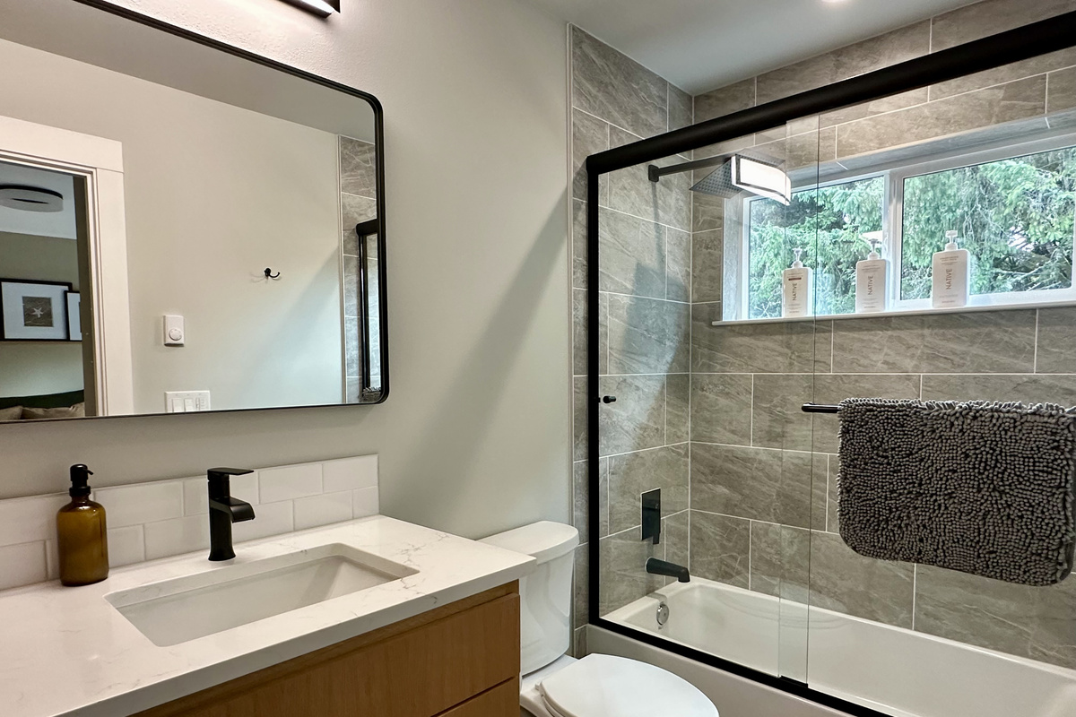 Soak in the primary suite's own tub after a beach day — quartz counters, glass doors, and nobody waiting on the bathroom.