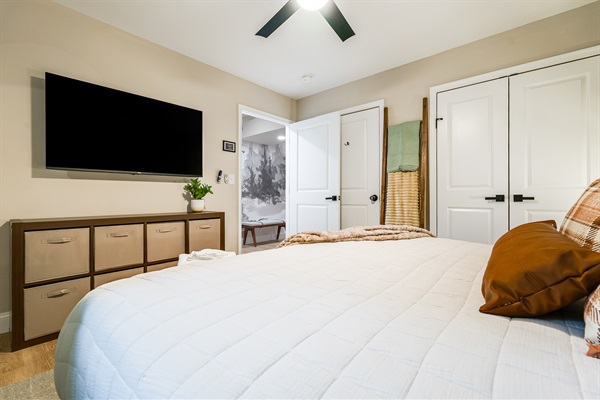 This inviting bedroom is designed for both comfort and convenience, featuring a large smart TV, storage for everyone’s essentials, and a warm, neutral palette. Ideal for parents who want to unwind with a movie after the kids are asleep down the hall.