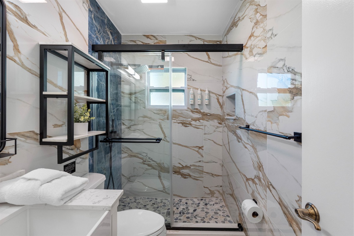 Soft tones, updated lighting, and a touch of greenery make this bathroom feel fresh and inviting.