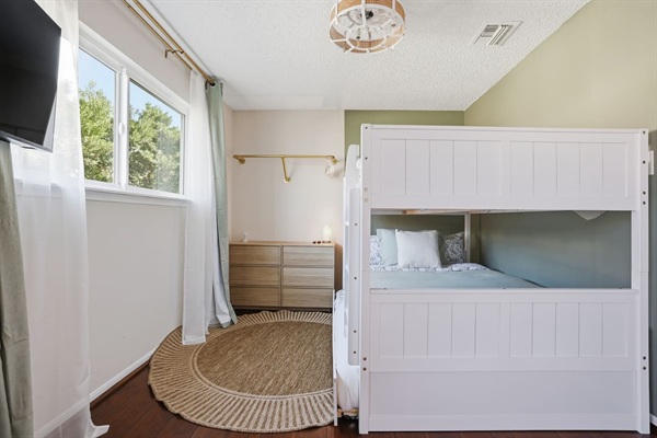 Spacious full-over-full bunk bed with twin trundle (lower bed suitable for toddlers). In-room TV and classic arcade game for entertainment. Includes dresser and closet space for easy storage. Changing pad available upon request