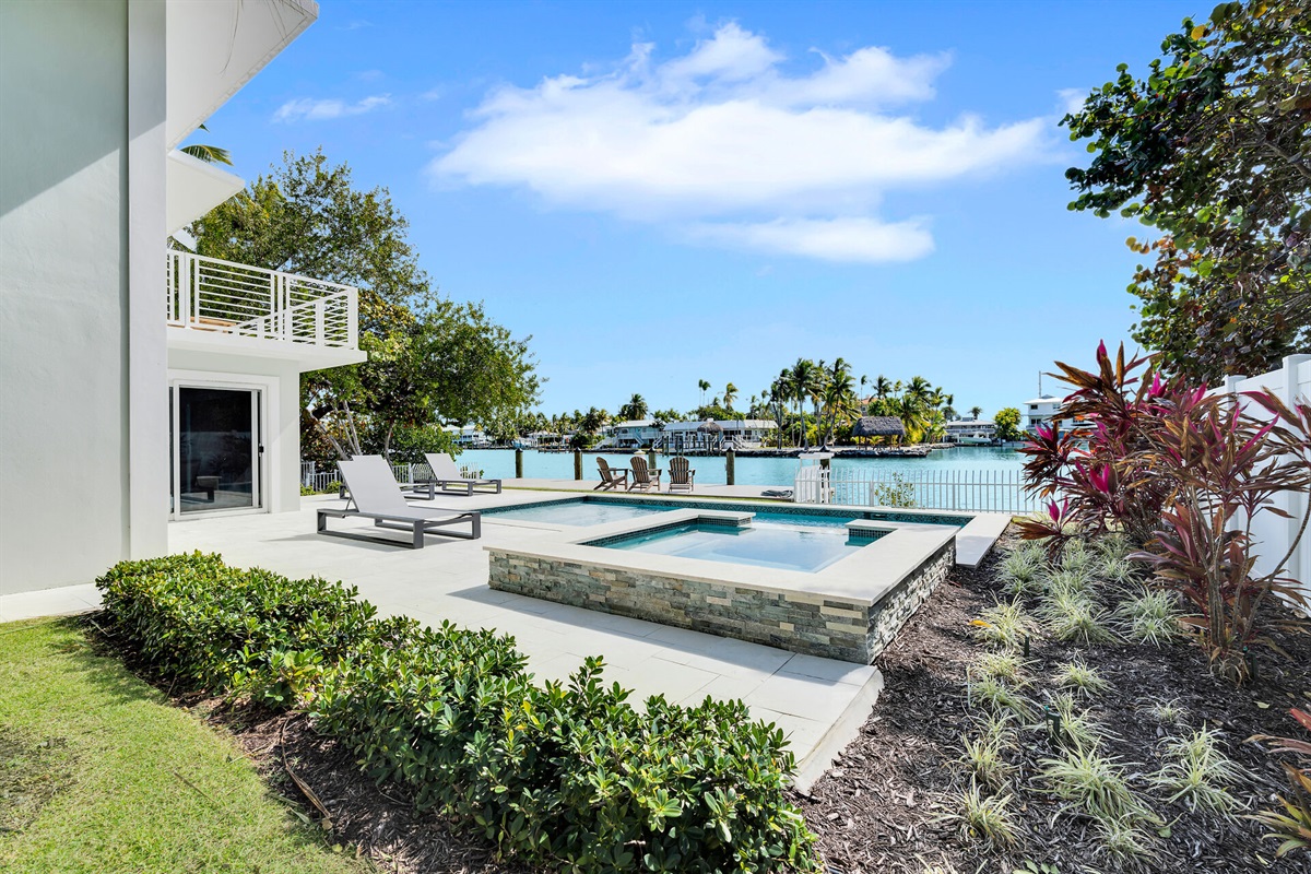 Pool and hot tub among natural landscaping.