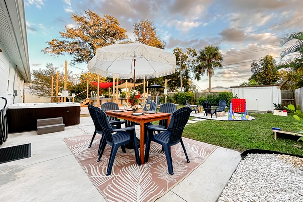 Back Yard with Patio Table with Botanical Umbrella, Hot Tub, Fire Pit, Yard Games, Deck, Full Size BBQ Grill, Sun Loungers, Heated Pool, Sun Shades, Lawn, & More