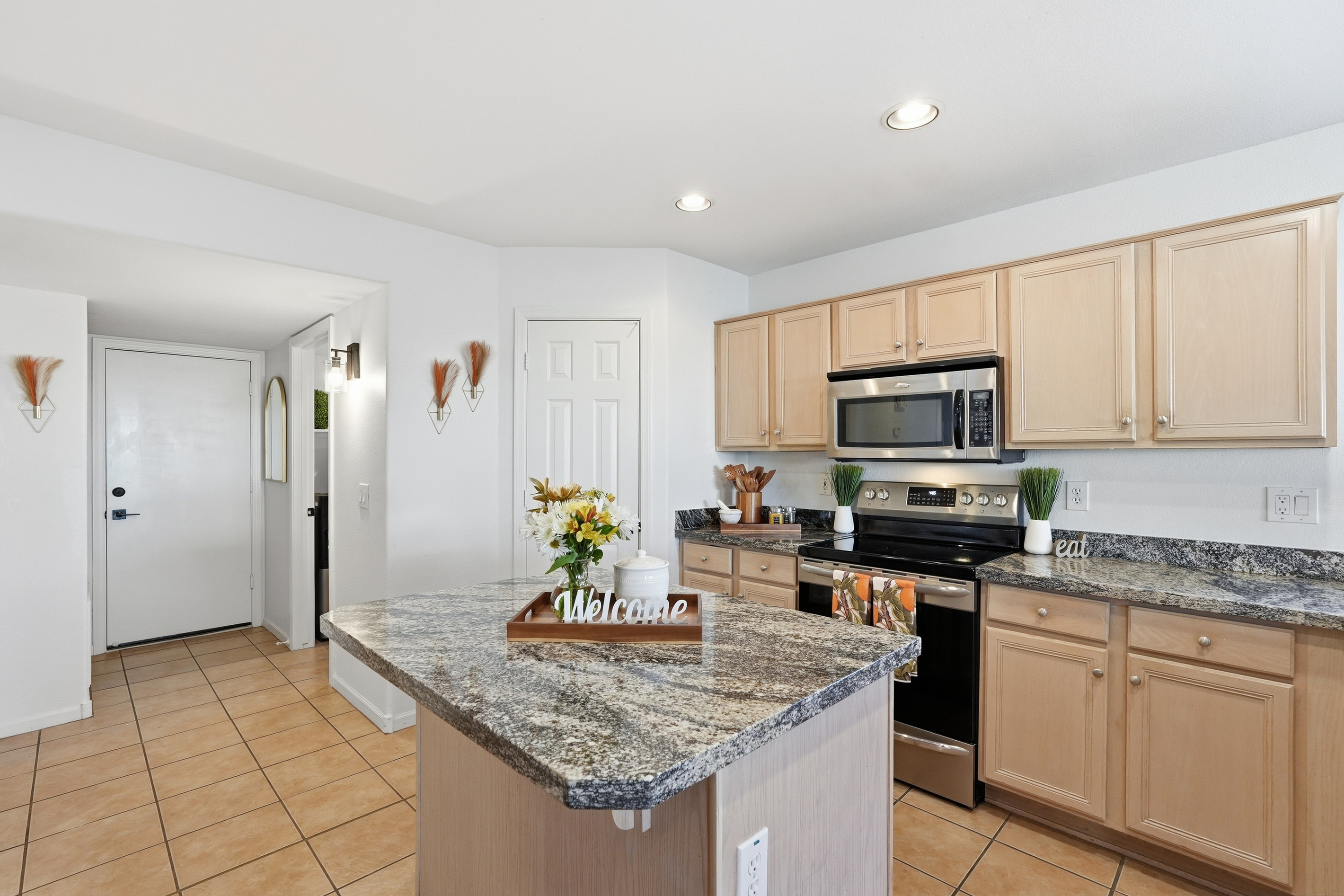 Full kitchen with granite island, appliances, and easy access from the entry for everyday meals.