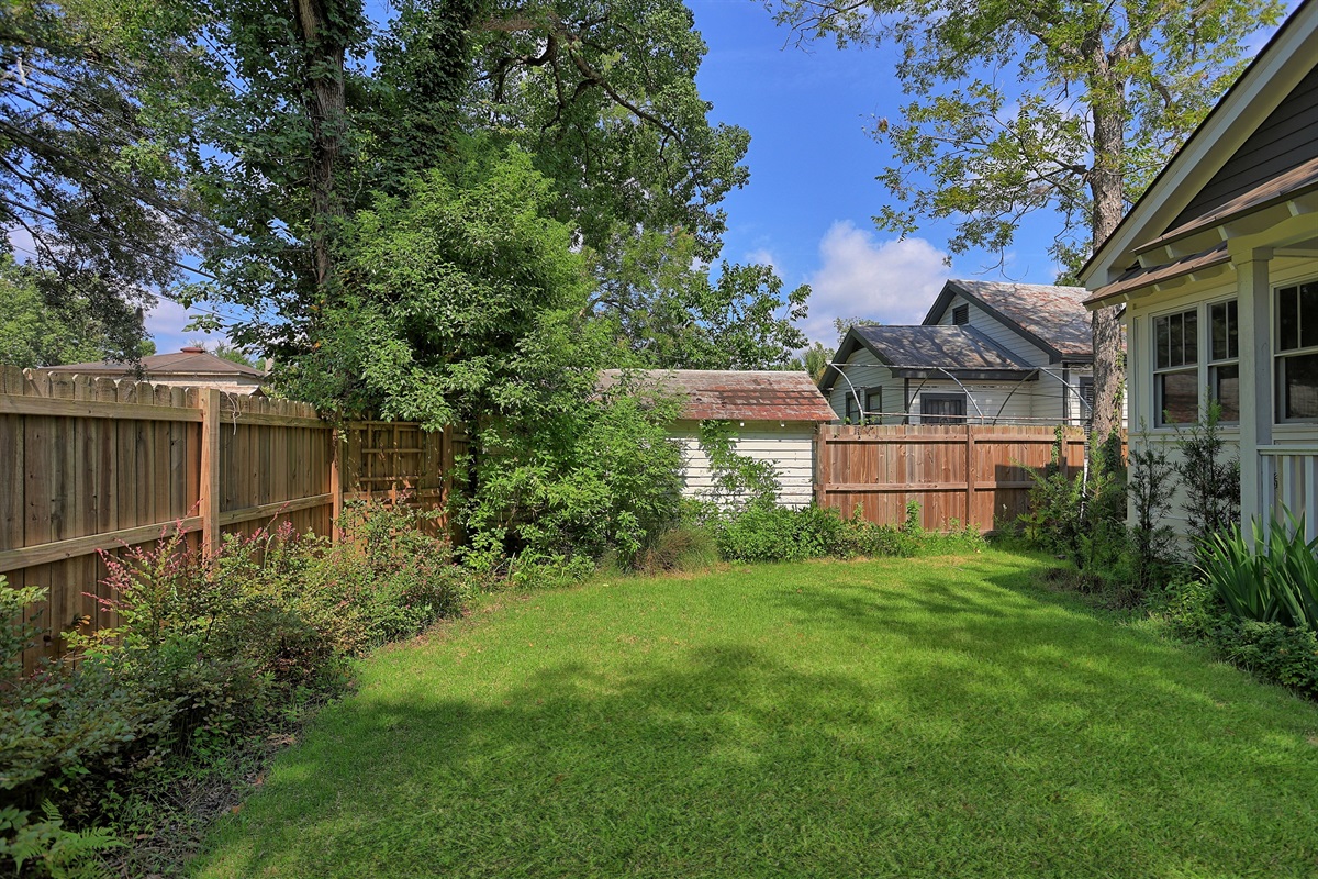 Mature landscaping surrounds the yard, providing a peaceful retreat from the city buzz.