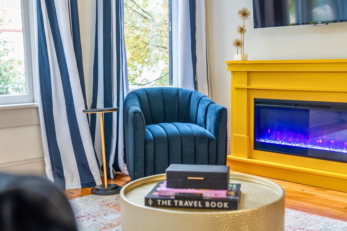 A cozy corner of the living room with a modern fireplace and plush seating invites you to sit back and unwind.