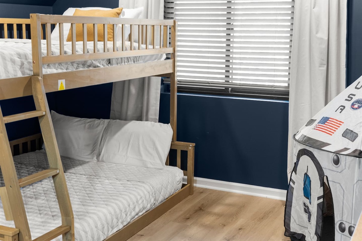 Low full-over-queen bunk bed with mattress close to the floor—safe, kid-friendly and Montessori-inspired.