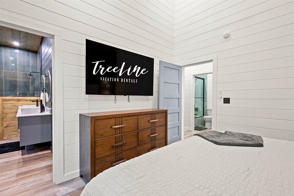 Designed for both comfort and convenience, this inviting king bedroom offers cozy bedding, a mounted TV, and a relaxing atmosphere that makes settling in at the end of the day easy.