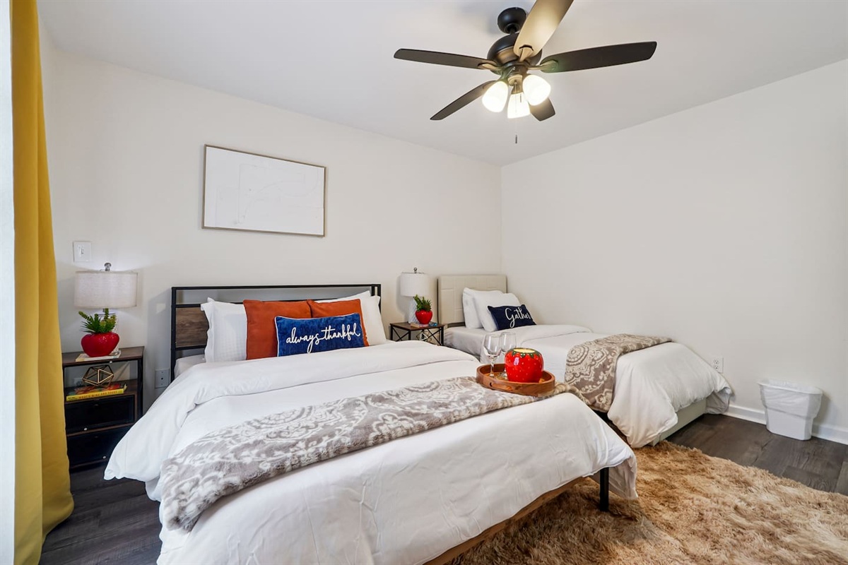 Another cozy bedroom featuring both a full bed and a twin bed, along with an Amazon Fire-powered Smart TV for your entertainment. This room includes 4 full-body towels, 4 washcloths, and 2 hand towels for your stay.