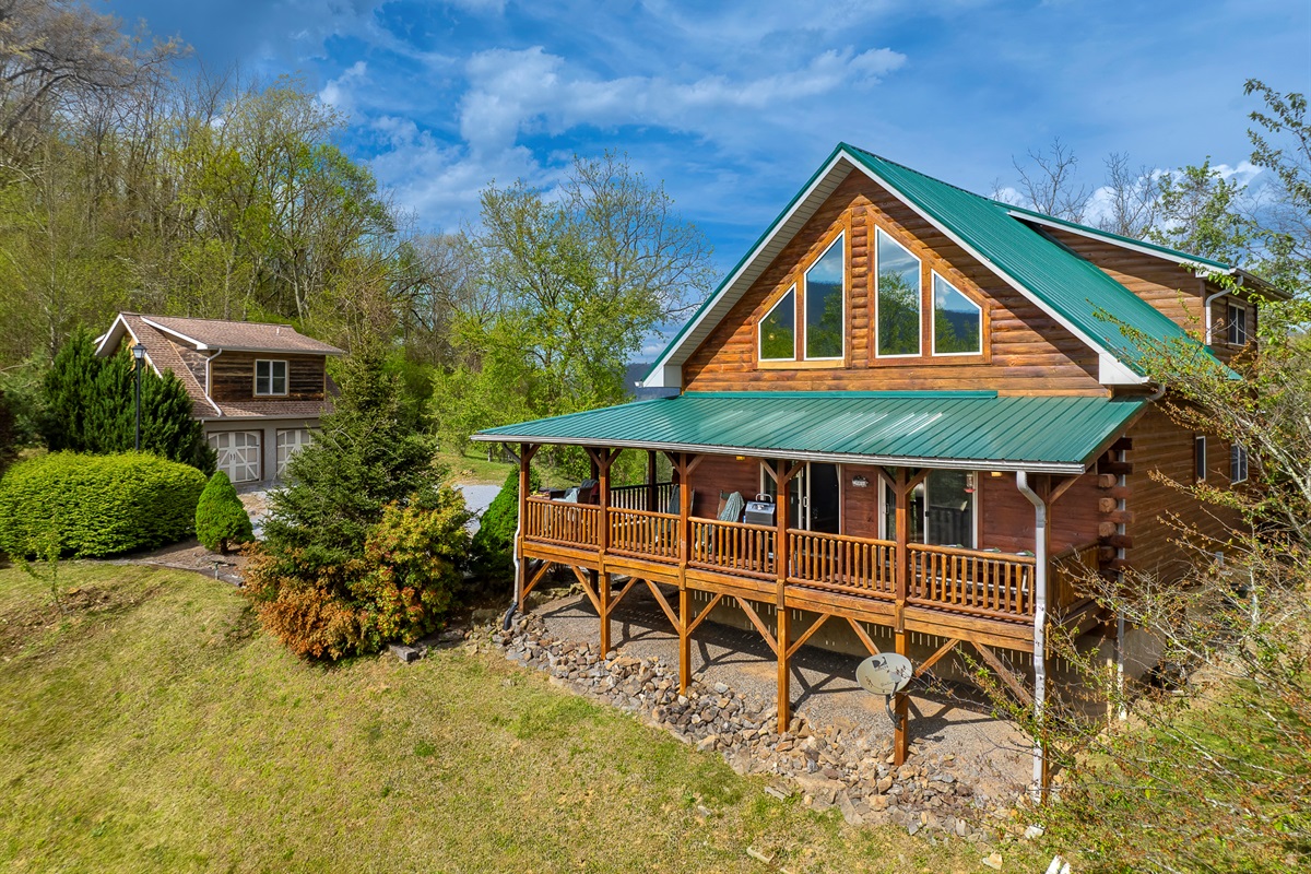 Exterior Retreat: Relax on the spacious porch, surrounded by lush greenery and mountain views!

