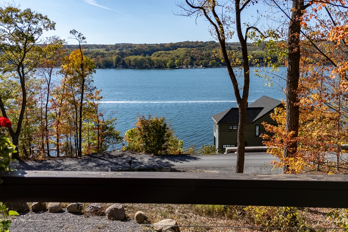 Lakefront glimpse with distant shore in autumn colors.