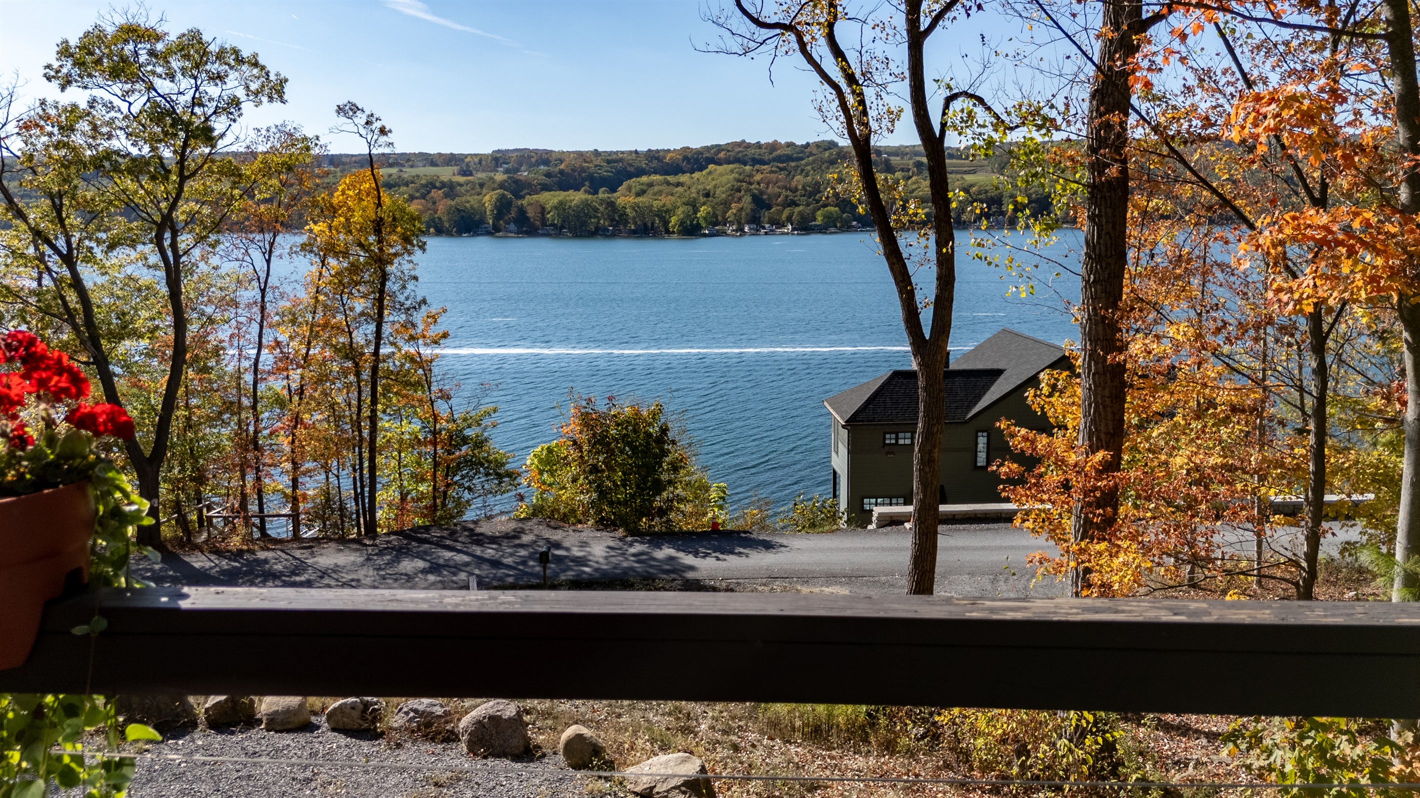 Lakefront glimpse with distant shore in autumn colors.