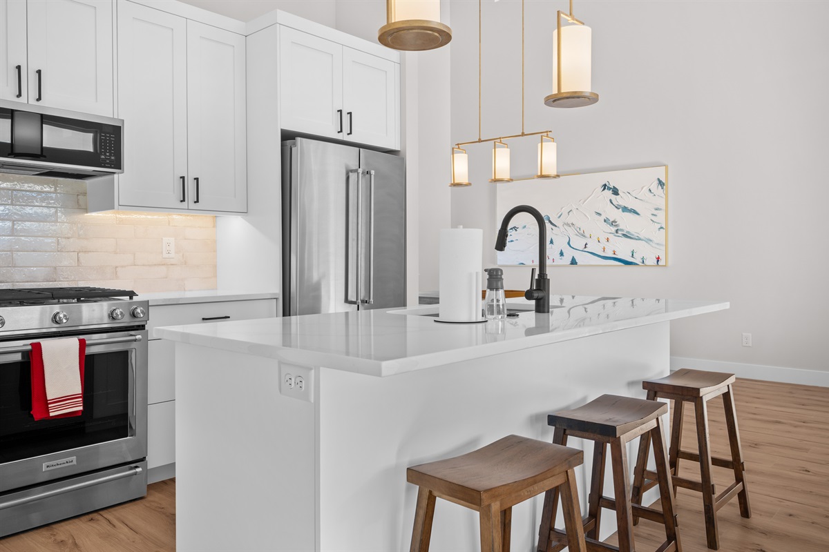 Bright, modern kitchen with island seating, stainless appliances, and modern décor.