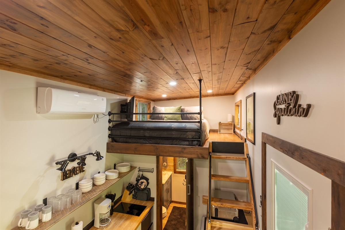 The queen loft offers a cozy elevated sleeping space with memory foam comfort and rustic charm.