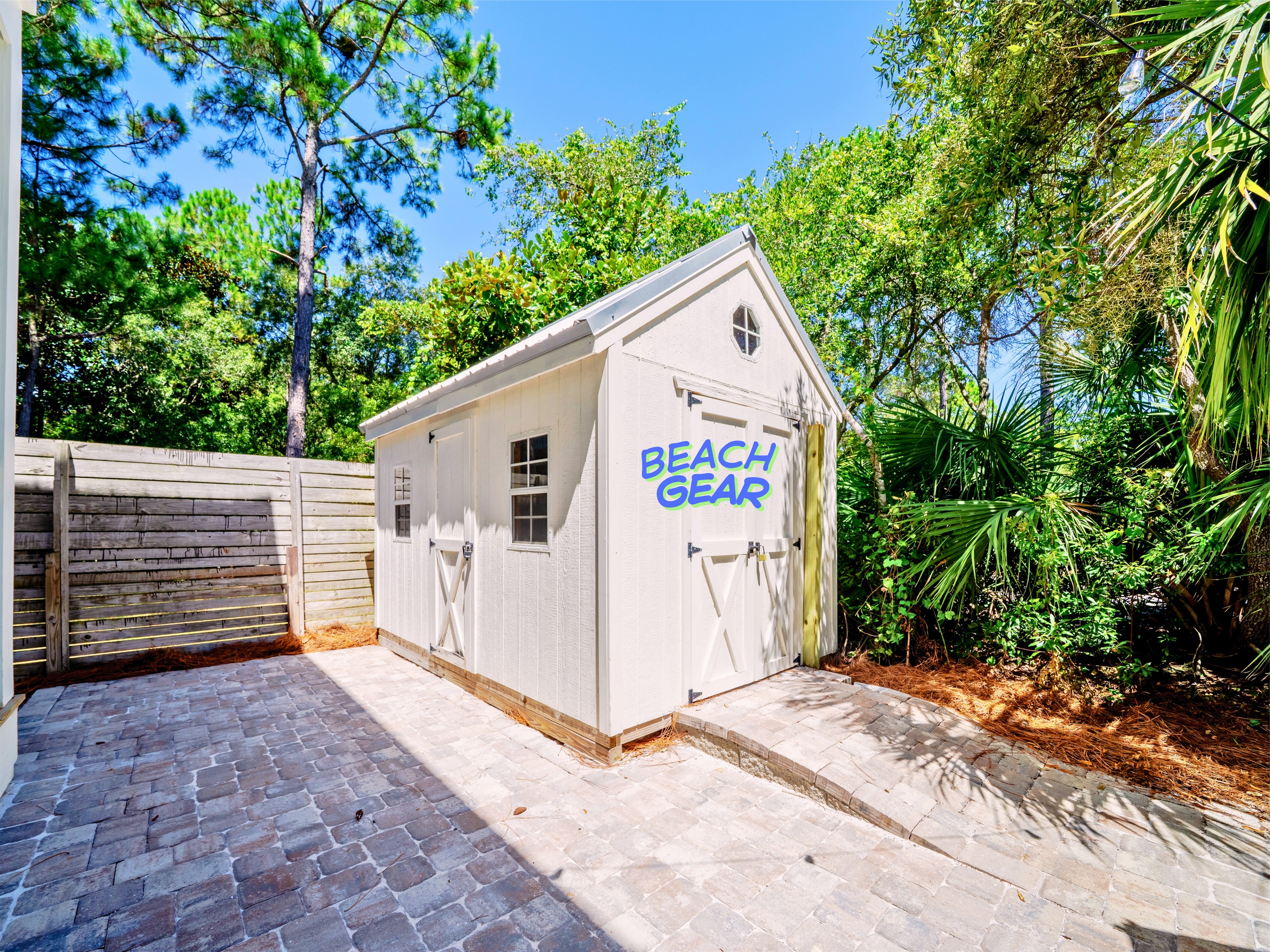 Shed stocked with beach gear—backpack chairs, wagon, and bikes ready for your adventure!