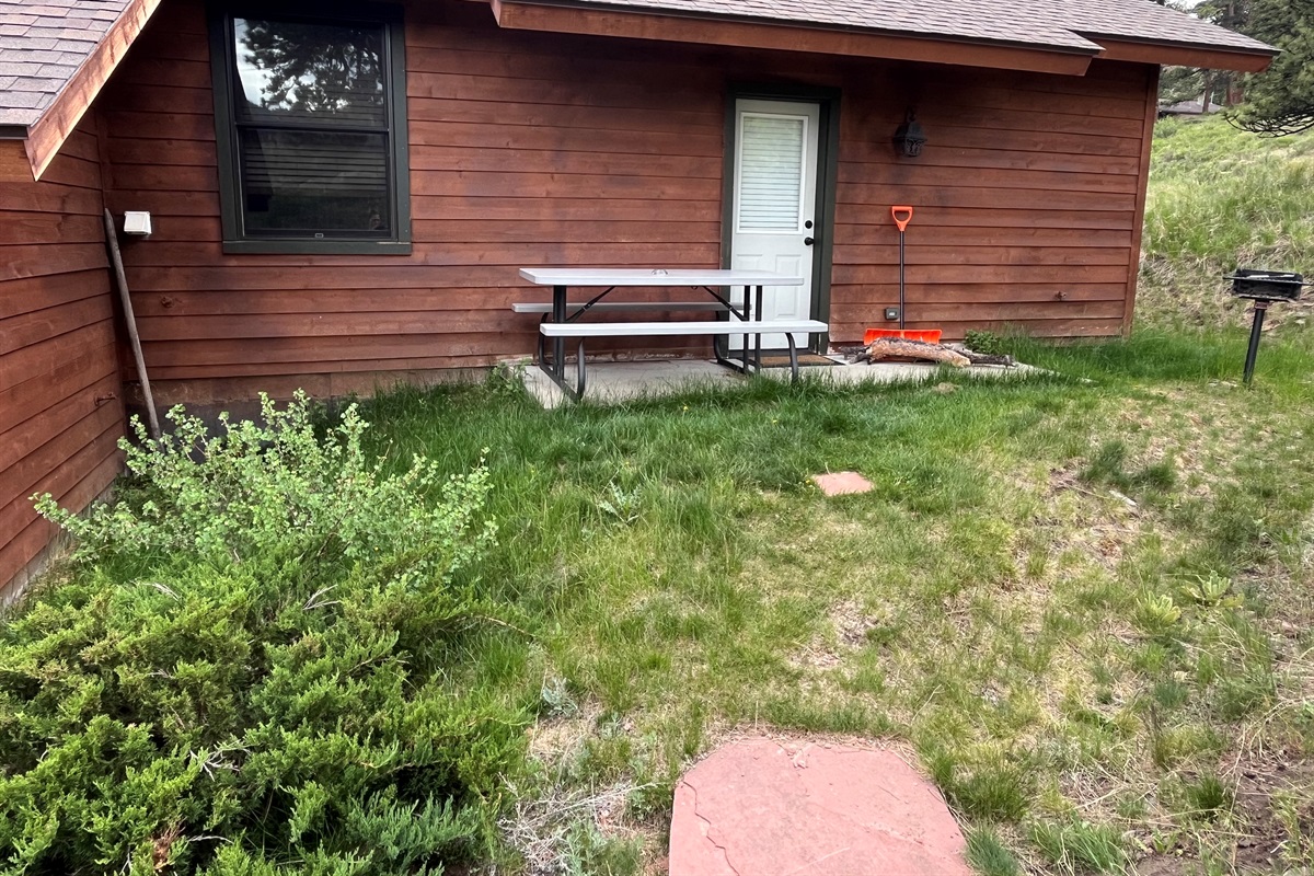 Another view of the picnic table and charcoal grill on back patio