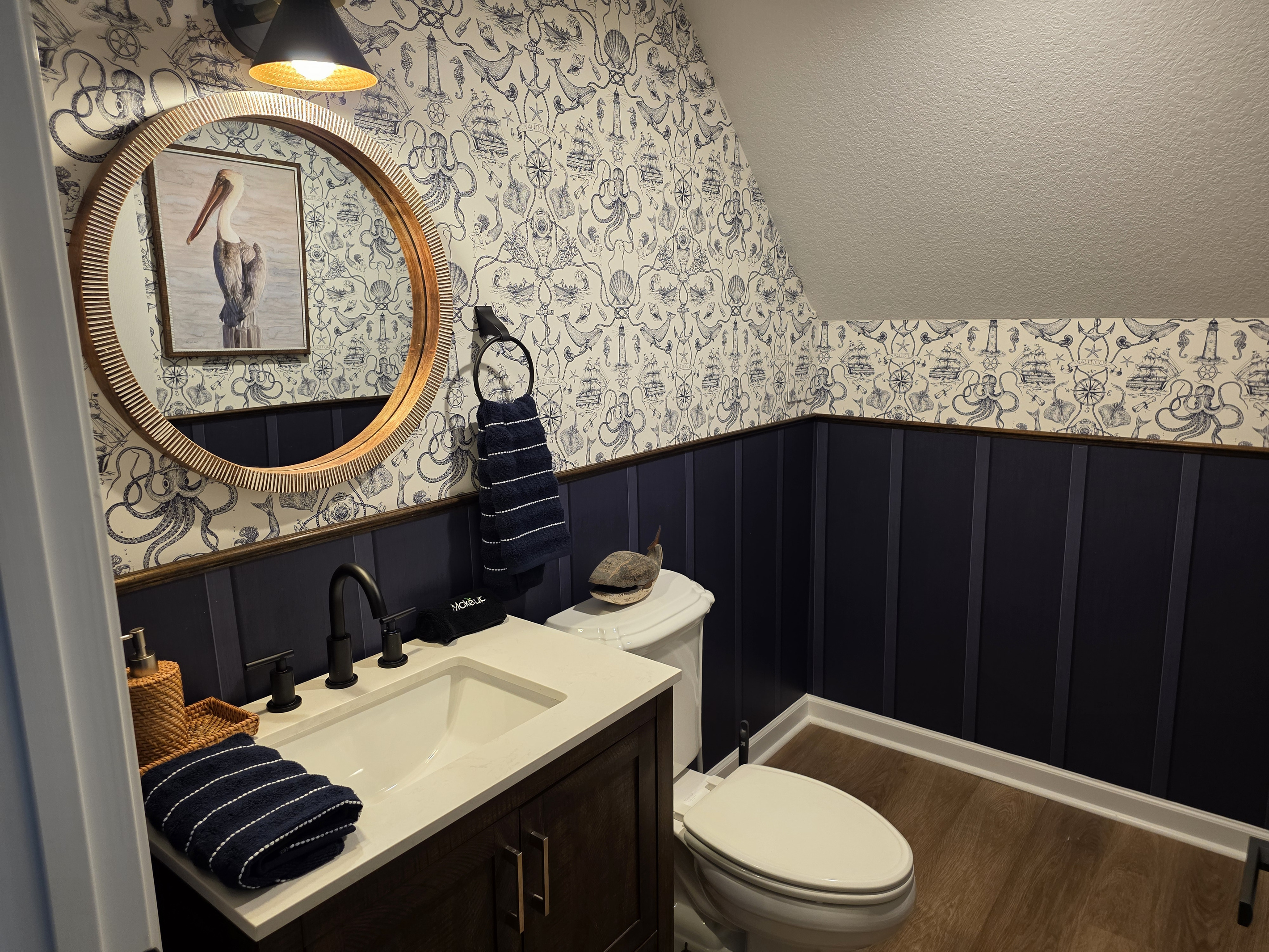 Second-floor powder room near the loft and deck, with stylish wallpaper, warm accents and convenient access.