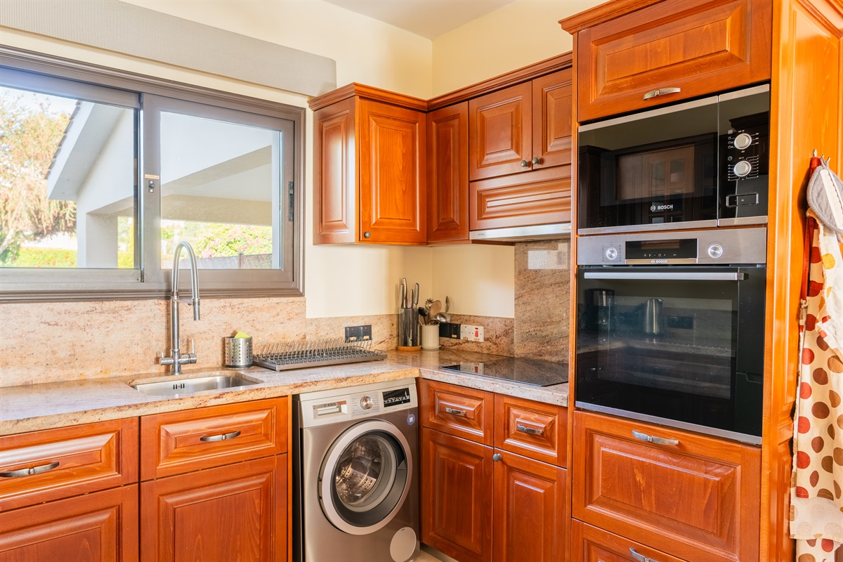 Enjoy cooking in a newly renovated kitchen featuring granite countertops and Bosch appliances, perfect for preparing meals with ease. The open layout connects seamlessly to the living area through a granite bar, making it easy to socialize while you cook.