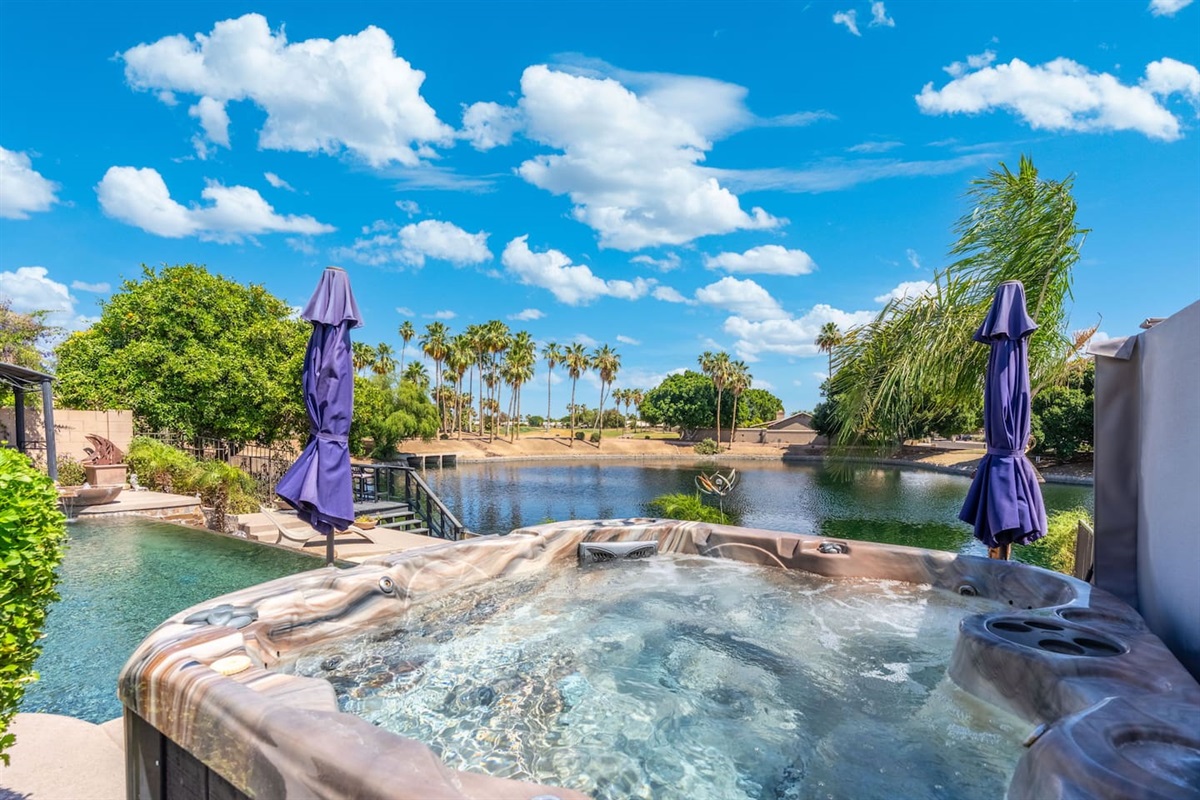 The hot tub jets are ready and the lake view is all yours — a perfect mid-afternoon soak with palm trees swaying and not a care in the world.