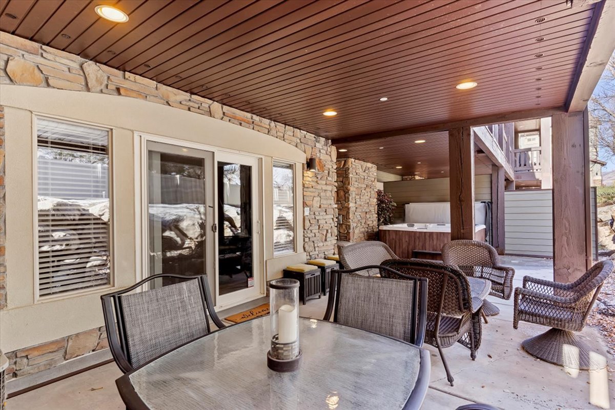 A beautifully designed patio space with dining and lounge areas, blending indoor comfort with outdoor charm for an elevated mountain experience.