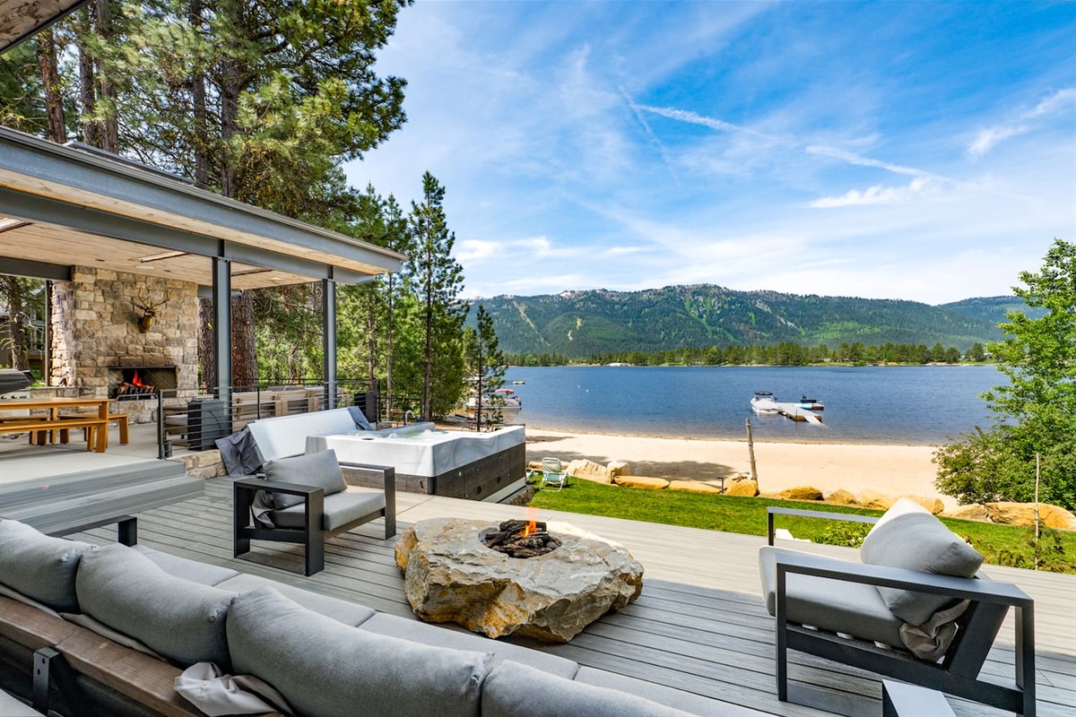 Relax in the hot tub while taking in panoramic lake and mountain views, all just outside the cozy stone fireplace patio