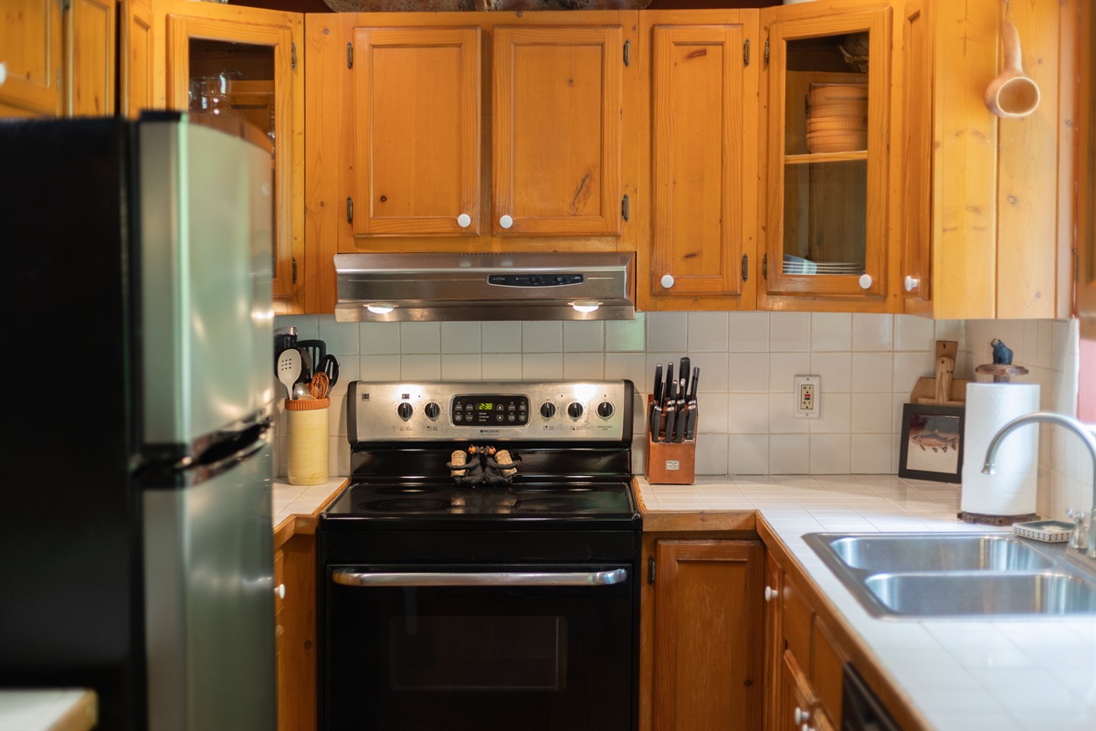 The fully equipped kitchen features a full-size range, refrigerator, and sink, making it easy to prepare meals during your stay.
