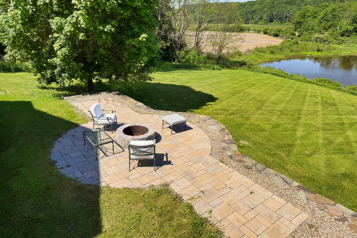 The fire pit in backyard overlooking the scenic pond.