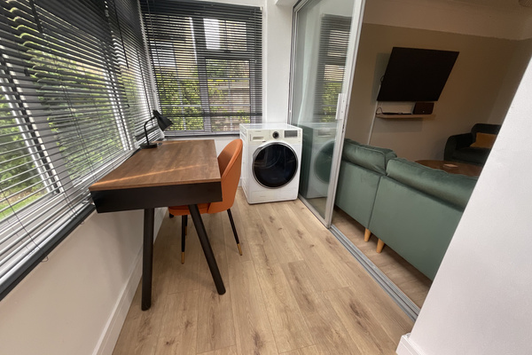 The porch area has a smart desk with WIFI speakers as well as the tumble dryer.