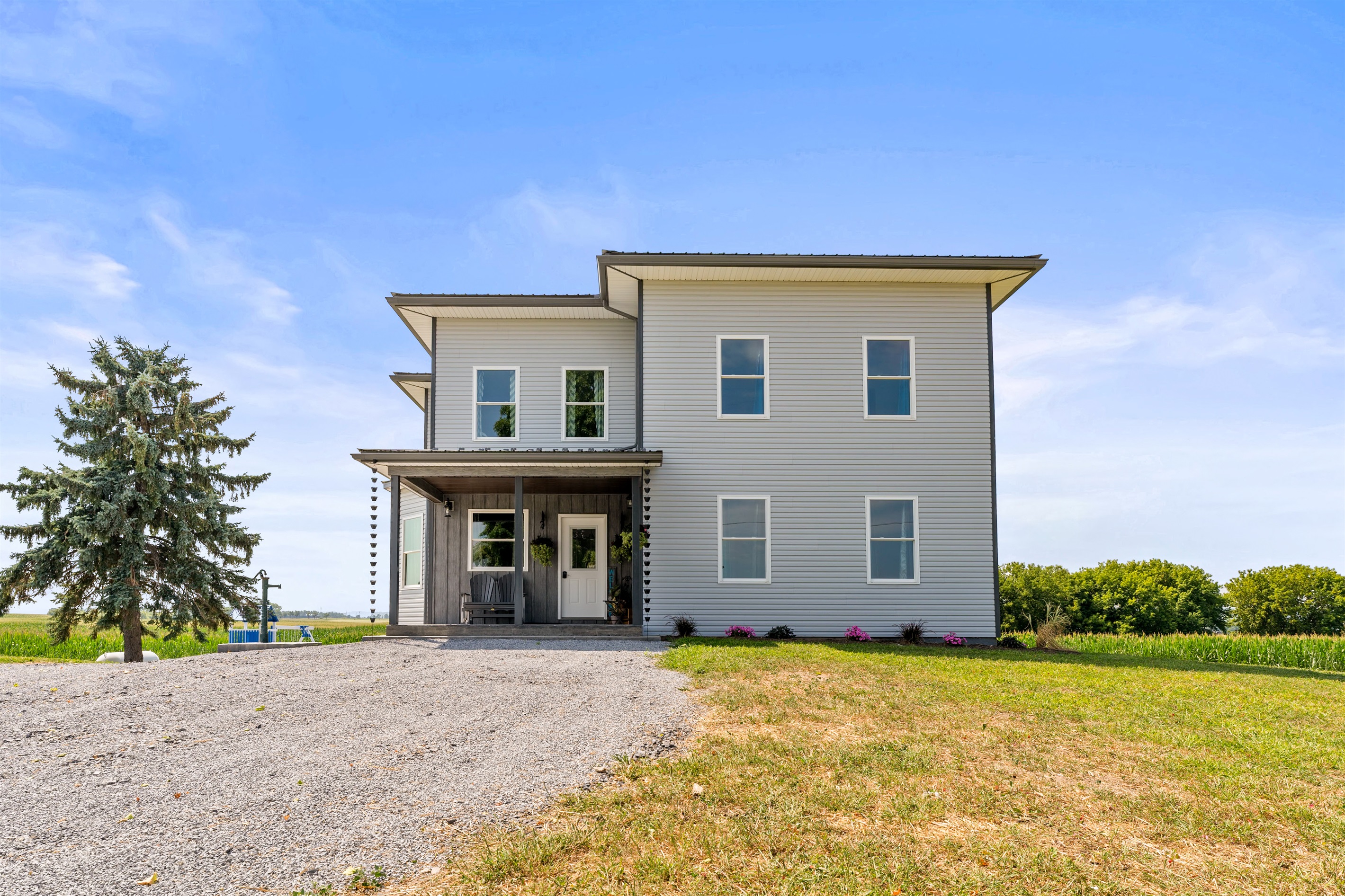 Beautiful modern farmhouse with clean lines, spacious windows, and a welcoming covered entryway.