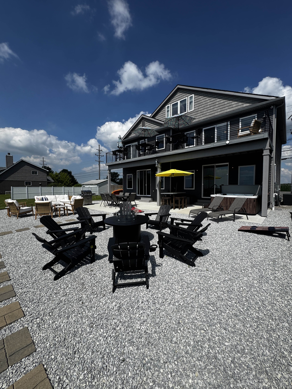 Outdoor fire pit seating area with surrounding lounge chairs—perfect for relaxing and gathering by the waterfront.