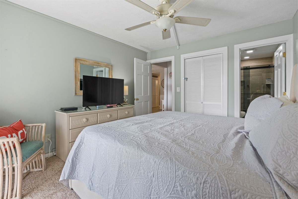 Master Bedroom with King bed, ensuite bathroom and oceanview balcony overlooking pools and ocean
